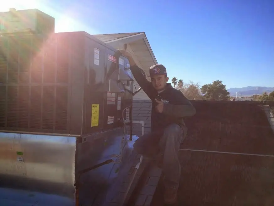 HVAC technician performing AC Tune-Up on a rooftop unit in Longwood